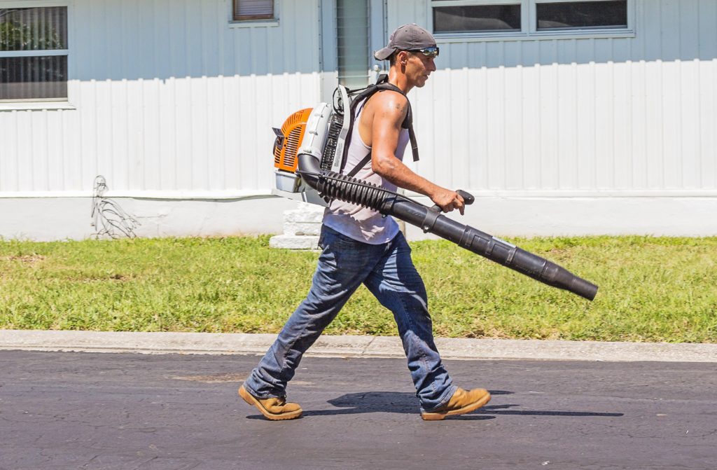 man walking with leaf blower